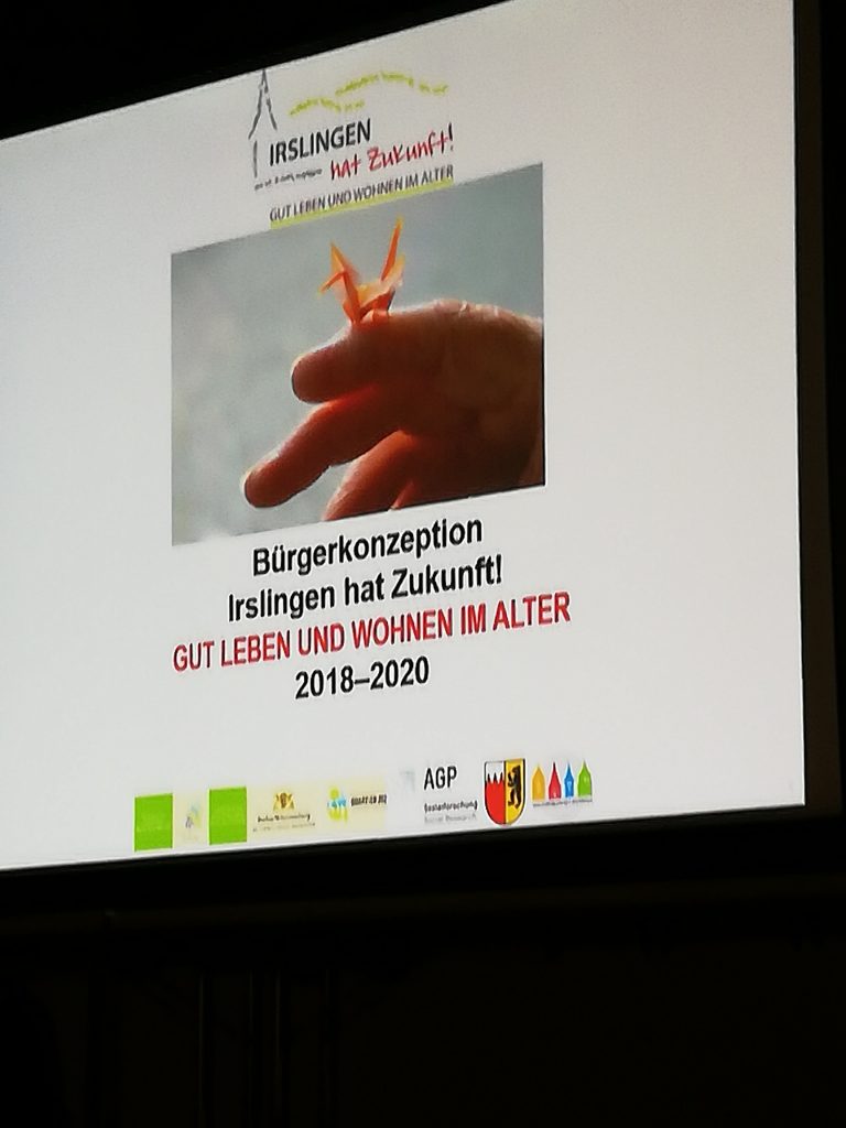 Präsentations-Folie mit der Aufschrift "Bürgerkonzeption Irslingen hat Zukunft! Gut Leben und Wohnen im Alter 2018-2020". Aufgenommen wurde das Bild im Rahmen eines Projektbesuchs in Irslingen.