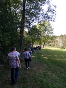 Auf dem Bild ist eine Gruppe von Personen zu erkennen, die in einem Waldstück läuft. Aufgenommen wurde das Bild im Rahmen eines Projektbesuchs in Schwäbisch Gmünd.