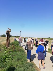 Zu erkennen ist eine Gruppe von Menschen, die an einem wolkenlosen warmen Tag in den Feldern spazieren geht. Aufgenommen wurde das Bild im Rahmen eines Projektbesuches in Schwäbisch Gmünd.