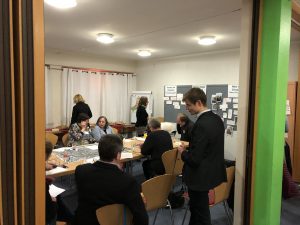 Zu sehen sind mehrere Personen, die sich in einem Raum befinden und miteinander sprechen. Aufgenommen wurde das Bild im Rahmen eines Nachbarschaftsgespräches in Pforzheim-Au.