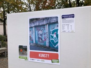 Auf dem Bild ist eine Pinnwand zu sehen, auf dem ein großes Plakat mit der Aufschrift "Kunst?" angebracht wurde. Neben dem Ausschnitt wurden zwei kleinere Plakate angebracht, die die Nachbarschaftsgespräche thematisieren. Aufgenommen wurde das Bild im Rahmen der Nachbarschaftsgespräche in Heilbronn.