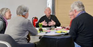 Zu sehen sind mehrere Menschen, die an einem Tisch sitzen und gemeinsam miteinander sprechen. Aufgenommen wurde das Bild im Rahmen der Nachbarschaftsgespräche in der Gemeinde Lichtenstein.