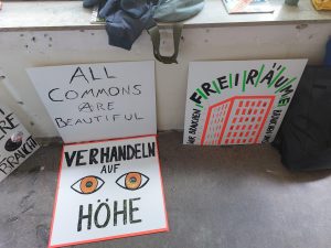 Zu sehen sind drei Plakate mit verschiedenen Aufschriften. Entstanden ist das Bild im Rahmen des Veranstaltungstages "You promised me a city" in Hannover.
